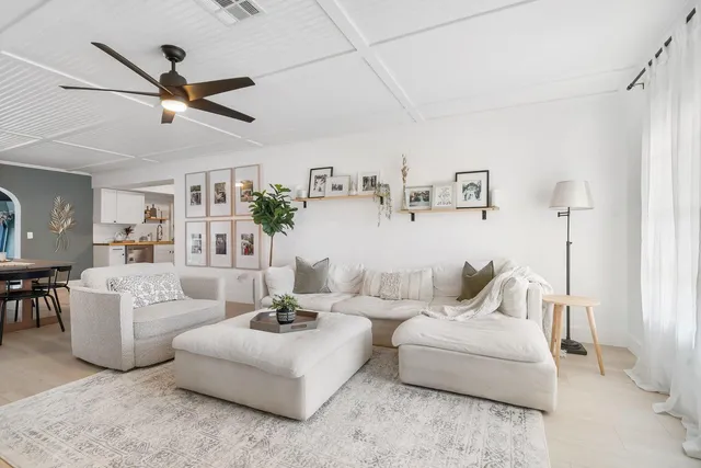 a living room with furniture and a ceiling fan