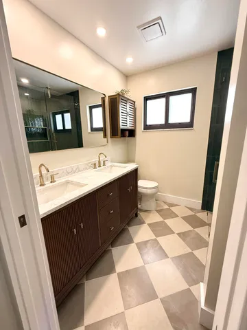 a bathroom with a sink a toilet and mirror