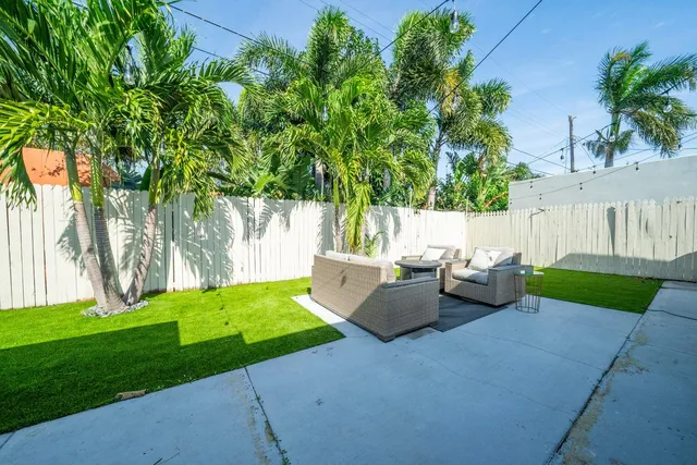 a view of a backyard with couches and palm trees
