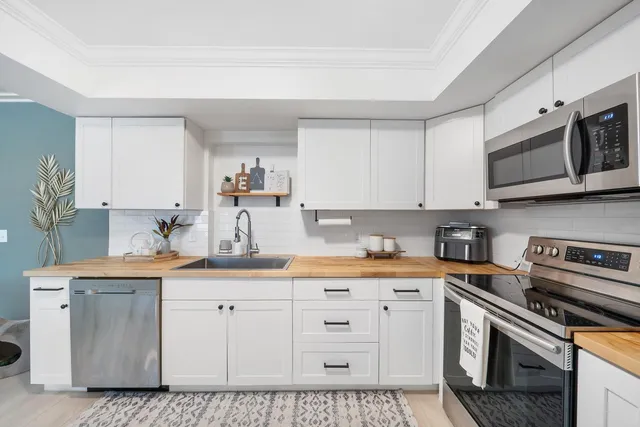 a kitchen with stainless steel appliances granite countertop a sink a stove and cabinets