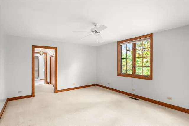 an empty room with a window and a ceiling fan