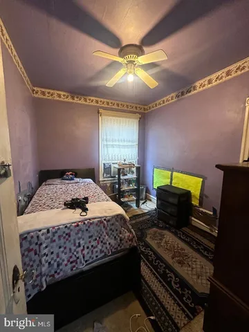 a spacious bedroom with a bed and a dresser with mirror