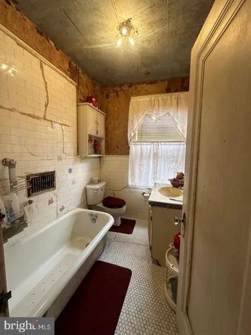 a bed sitting in a spacious bedroom next to a window