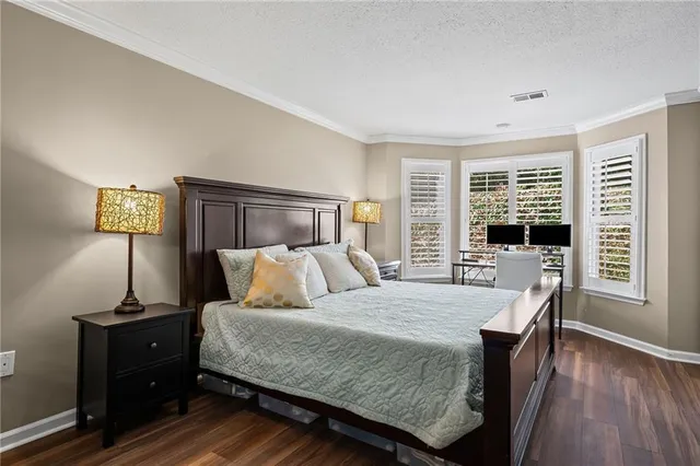 a bedroom with a bed and a potted plant on dresser