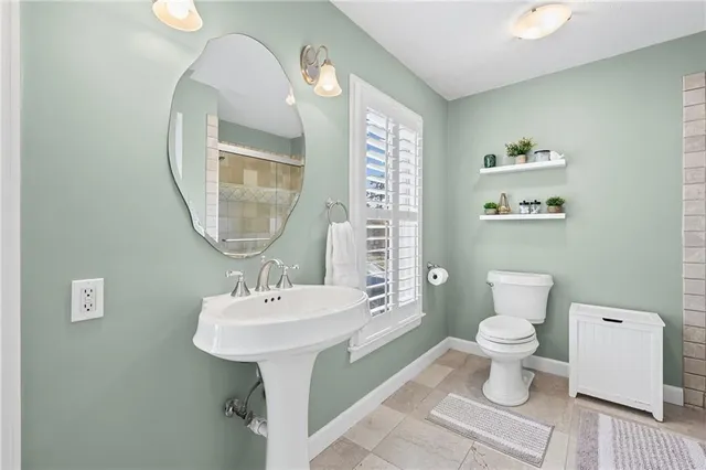 a bathroom with a sink toilet and a mirror