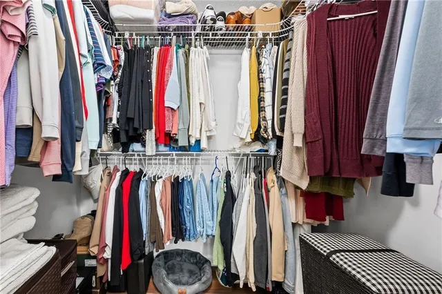 a view of walk in closet with clothes