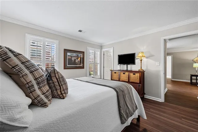 a spacious bedroom with a bed and a flat screen tv