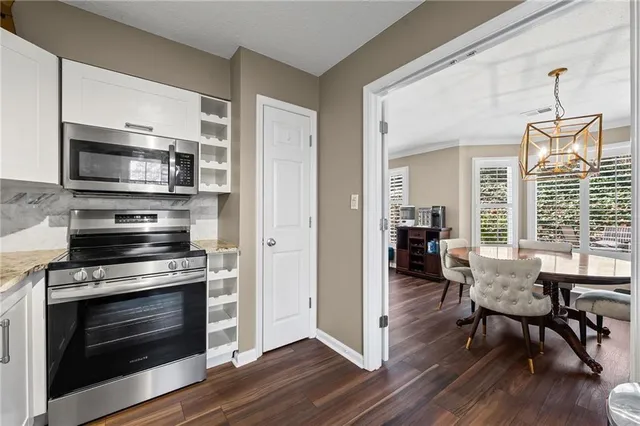 a view of kitchen with microwave stove dining table and chairs