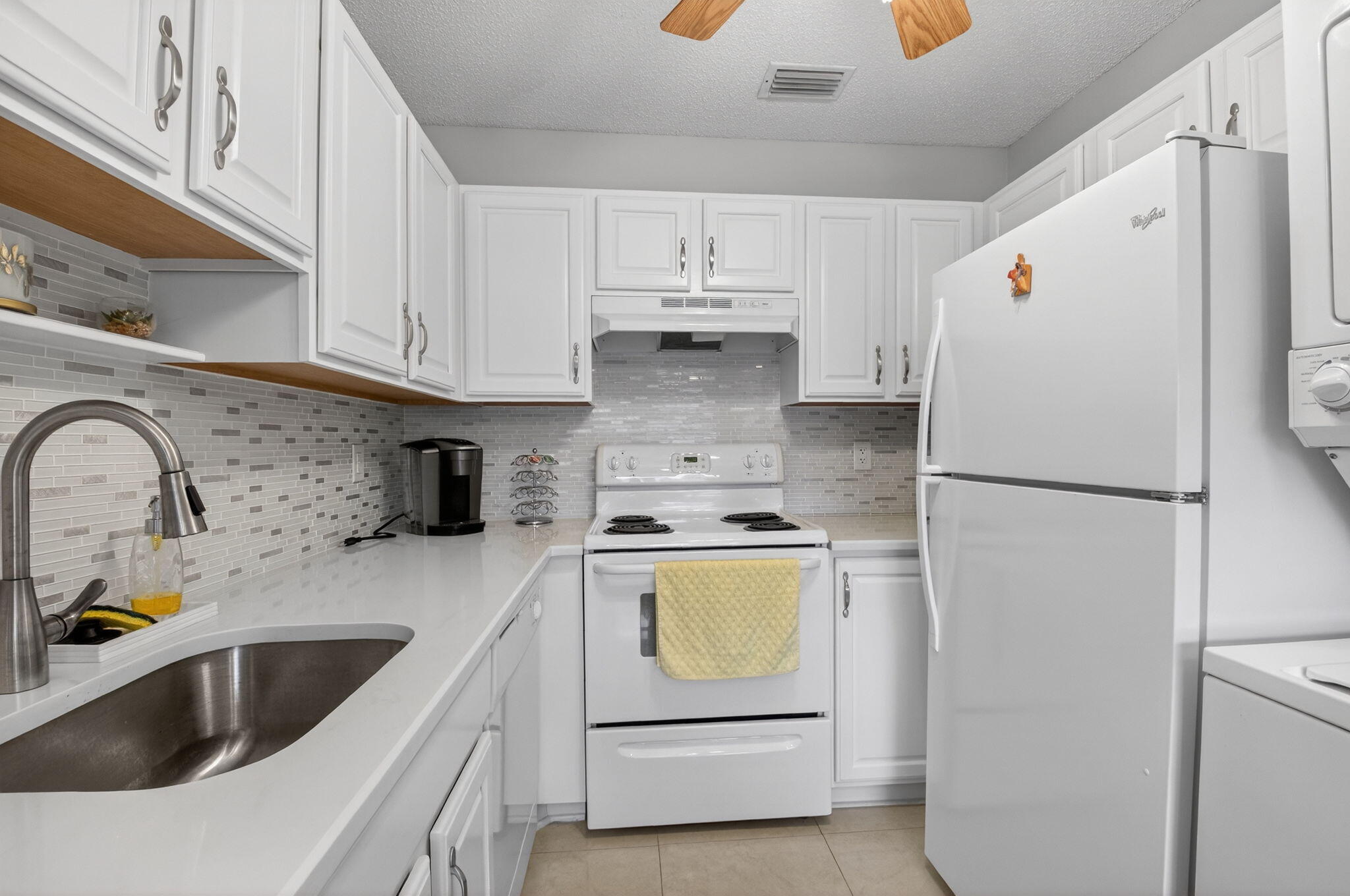 8633 Chevy Chase Drive Boca Raton, FL 33433 - Photo 11 of 43 a kitchen with refrigerator a stove a sink and cabinets