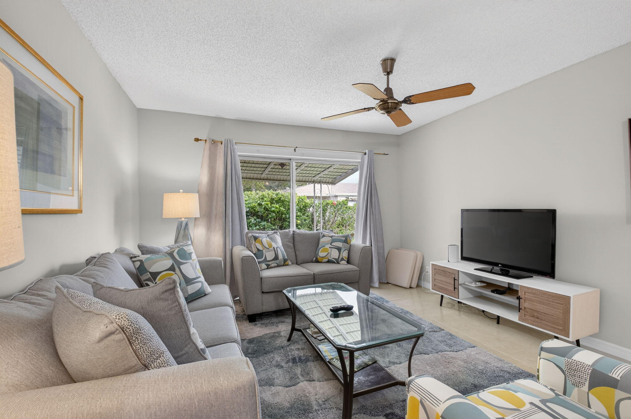 8633 Chevy Chase Drive Boca Raton, FL 33433 - Photo 5 of 43 a living room with furniture and a flat screen tv