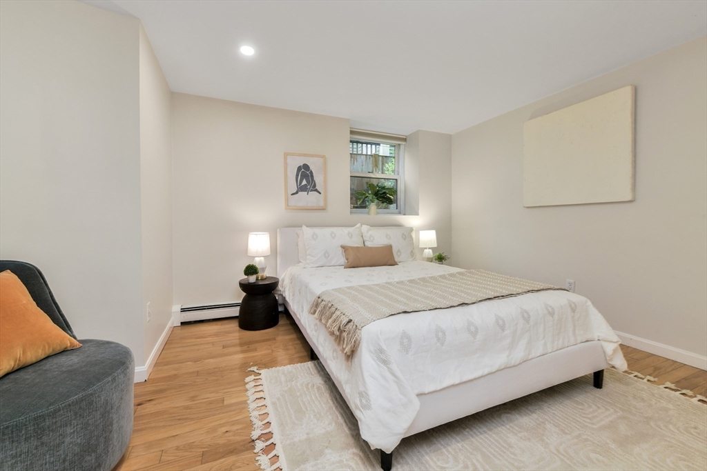 111 Inman Street, Unit A Cambridge, MA 02139 - Photo 13 of 18 a bedroom with a bed and a couch