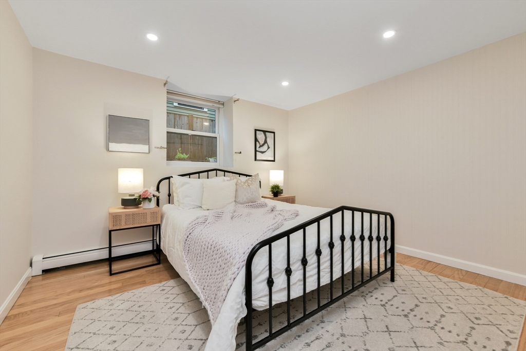 111 Inman Street, Unit A Cambridge, MA 02139 - Photo 14 of 18 a bedroom with a bed and painting on the wall