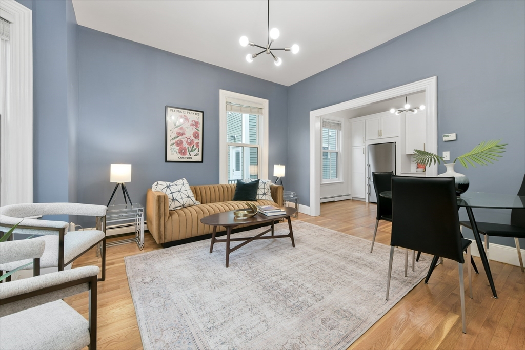 111 Inman Street, Unit A Cambridge, MA 02139 - Photo 5 of 18 a living room with furniture and a chandelier