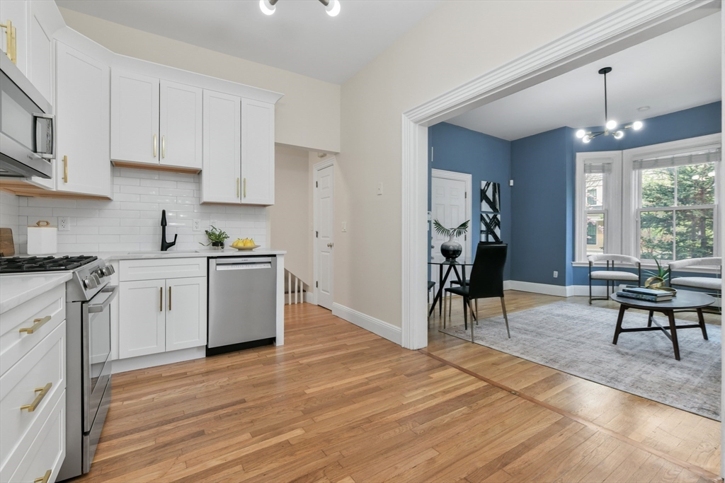 111 Inman Street, Unit A Cambridge, MA 02139 - Photo 7 of 18 a view of a kitchen with workspace and wooden floor