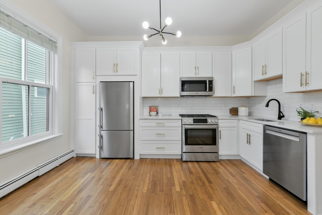 111 Inman Street, Unit A Cambridge, MA 02139 - Photo 9 of 18 a kitchen with a refrigerator stove and microwave