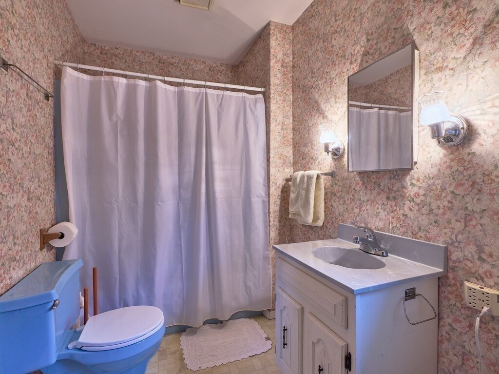 32 Wayne Street Worcester, MA 01603 - Photo 11 of 35 a bathroom with a sink a toilet and shower curtain