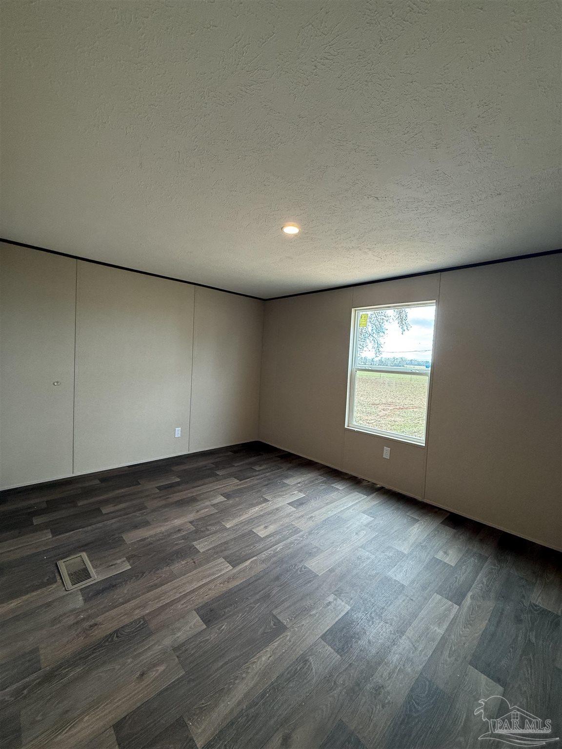 4460 Custer Lane Jay, FL 32565 - Photo 15 of 16 an empty room with wooden floor and windows