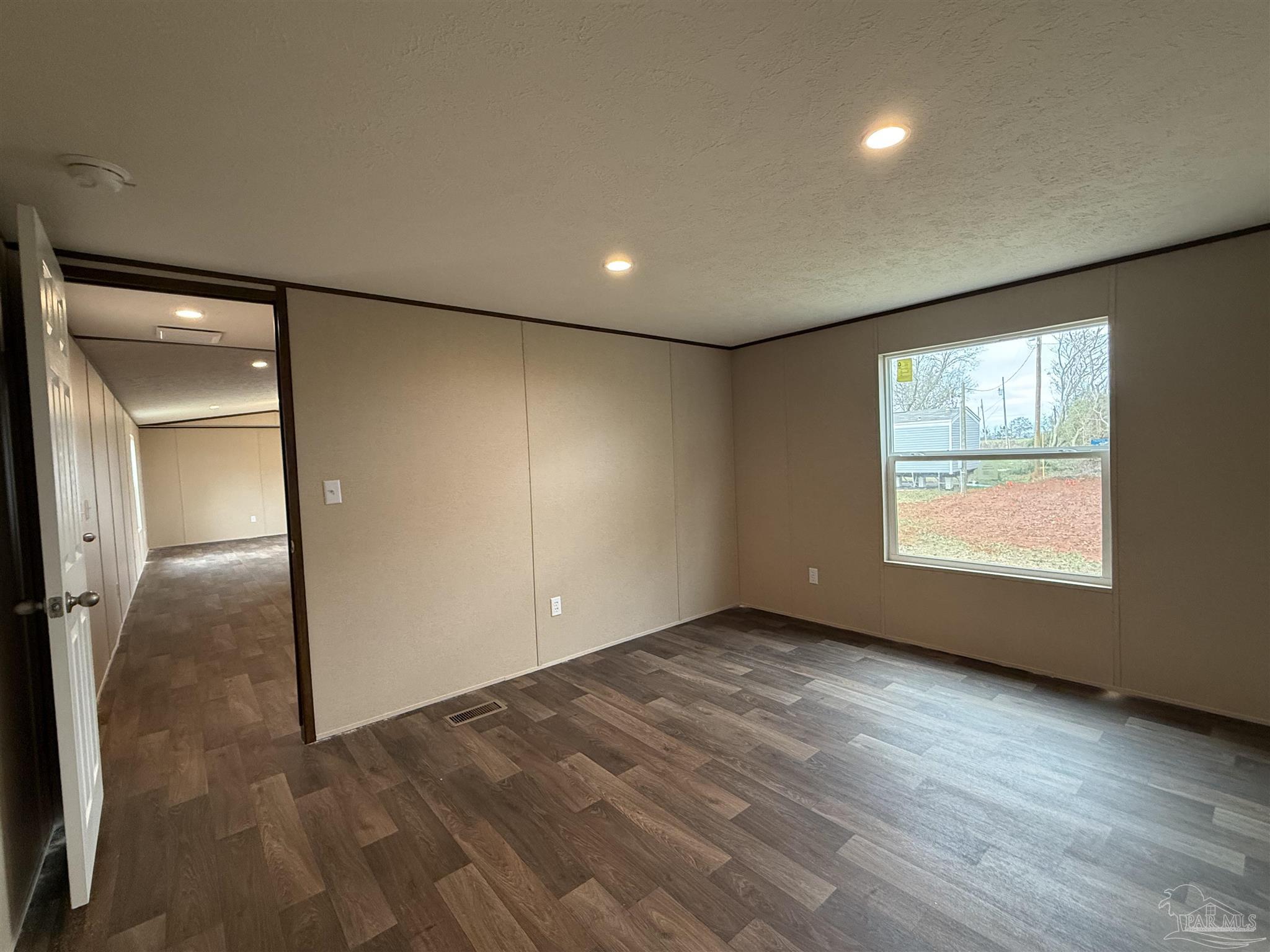 4460 Custer Lane Jay, FL 32565 - Photo 5 of 16 an empty room with wooden floor and windows