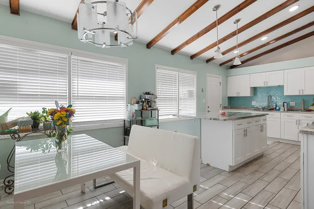 a kitchen with kitchen island granite countertop lots of white stainless steel appliances cabinets and a large window