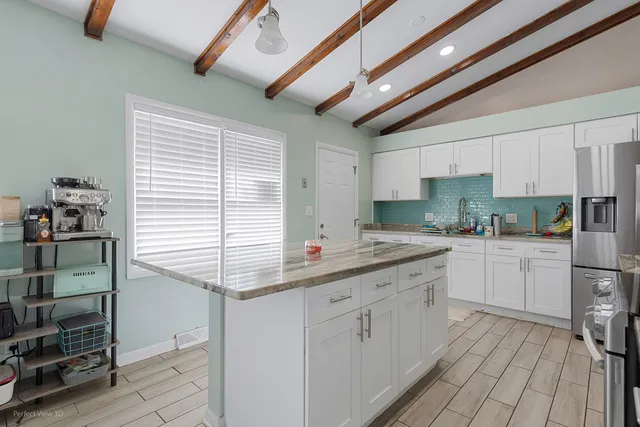 a kitchen with kitchen island granite countertop lots of counter top space and appliances