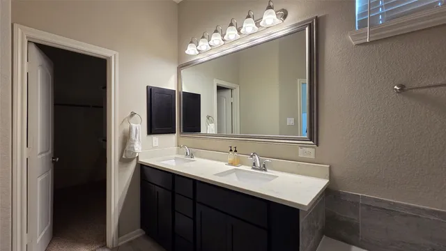 a bathroom with a double vanity sink and a mirror