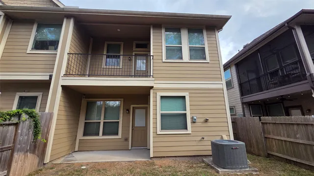a view of white house with large windows and plants