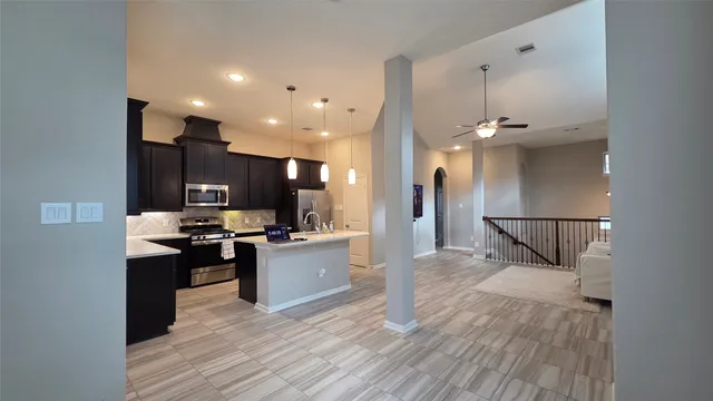 a kitchen view with stainless steel appliances kitchen island hardwood floor and a sink