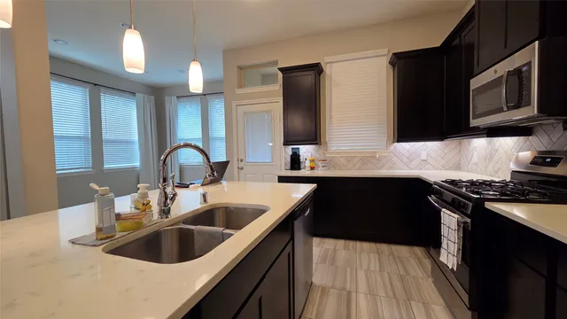 a kitchen with a sink and a stove with wooden floor