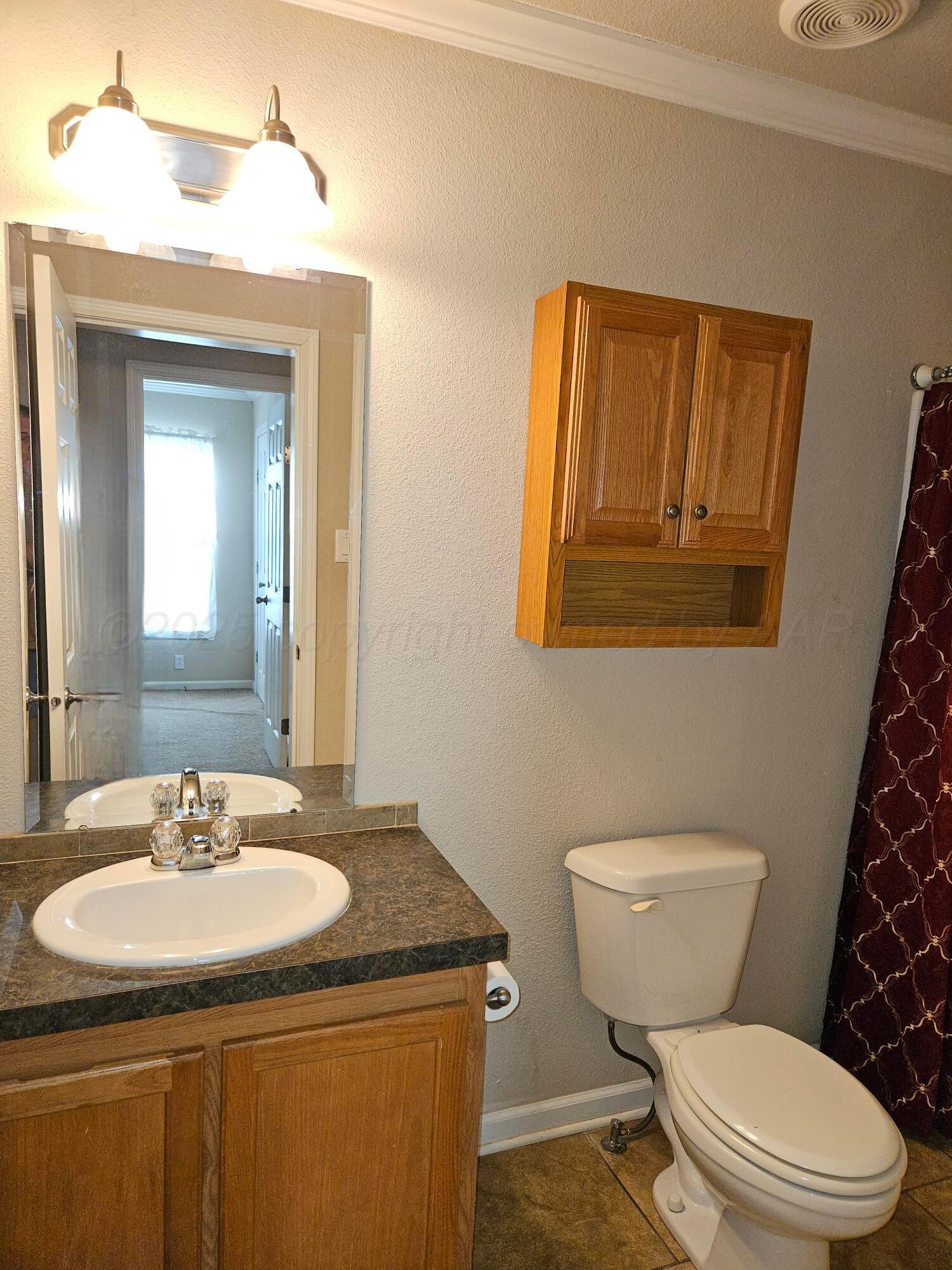 703 Martin Avenue Groom, TX 79039 - Photo 26 of 37 a bathroom with a toilet sink and mirror