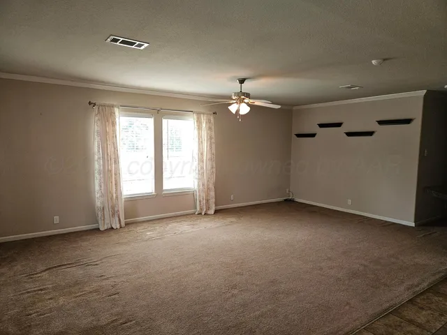 an empty room with a chandelier fan