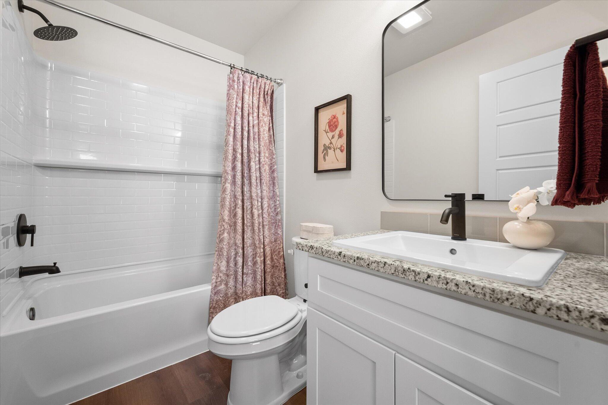 5505 Smith Street Lubbock, TX 79416 - Photo 14 of 18 a bathroom with a granite countertop bathtub sink vanity mirror and toilet