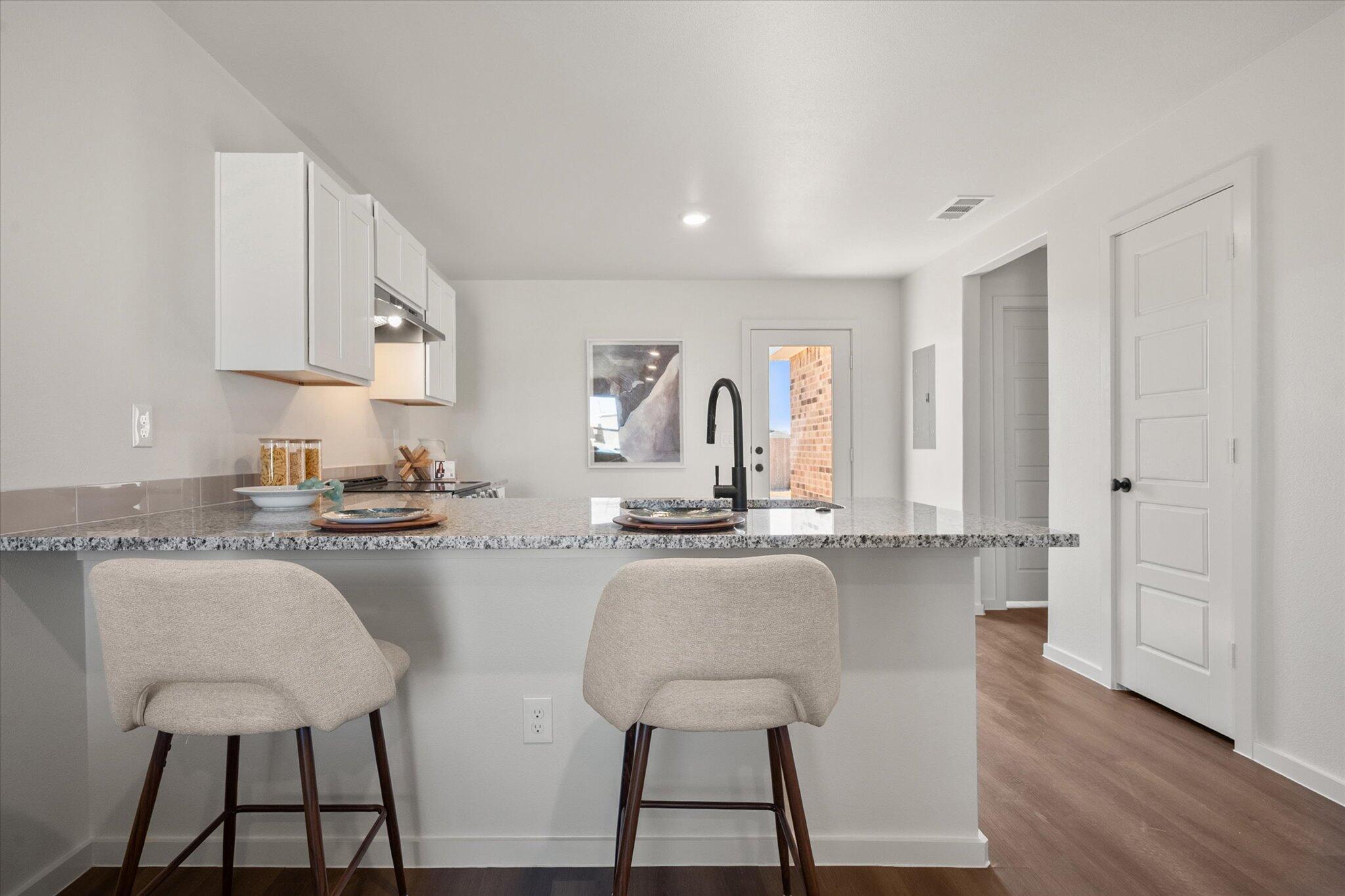 5505 Smith Street Lubbock, TX 79416 - Photo 7 of 18 a kitchen with granite countertop white cabinets and stainless steel appliances