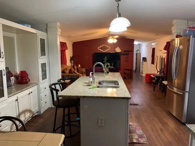 a kitchen with a sink and a wooden floor