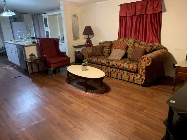 a living room with furniture a fireplace and wooden floor