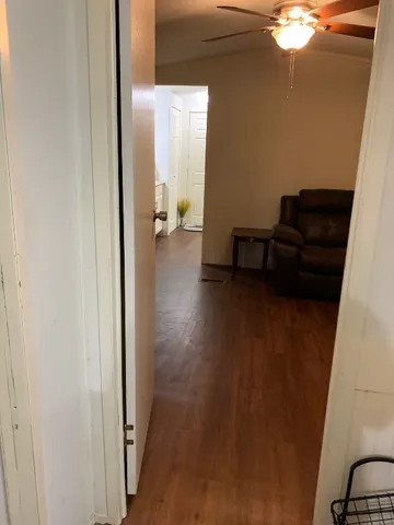 a view of an empty room with furniture and hardwood floor