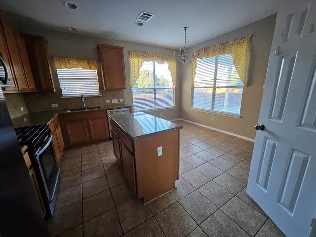 a kitchen with stainless steel appliances granite countertop a sink stove and granite counter top
