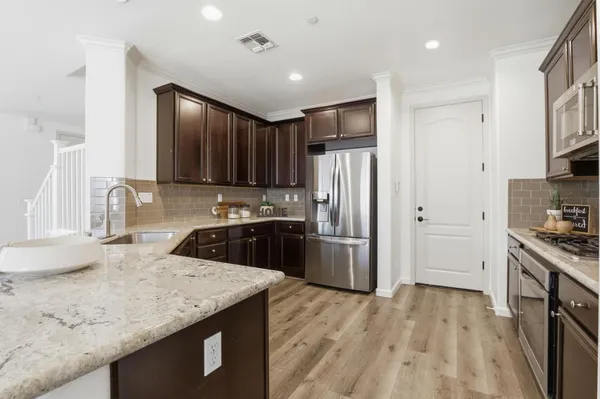 a kitchen with stainless steel appliances granite countertop a sink stove and refrigerator