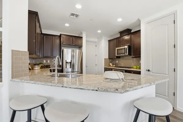 a kitchen with stainless steel appliances granite countertop a sink refrigerator and cabinets