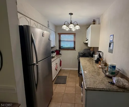 a kitchen with granite countertop a refrigerator a stove and a sink