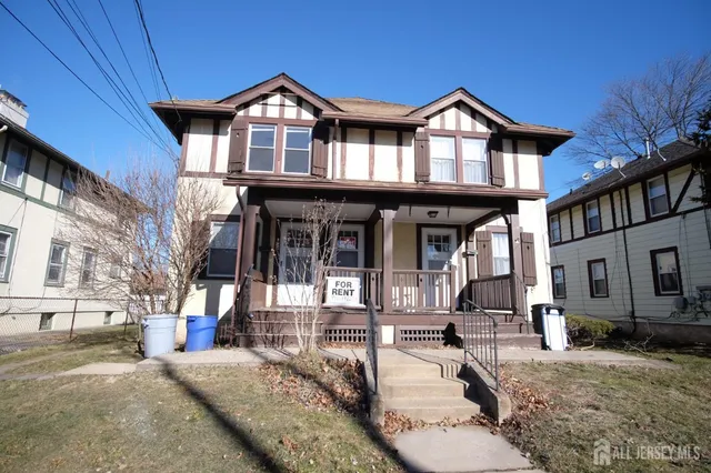 a view of a big house with large windows and a yard