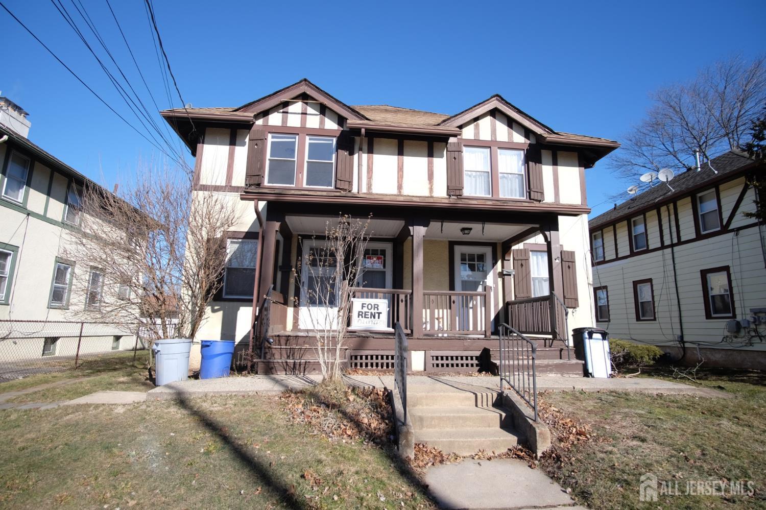 a view of a big house with large windows and a yard