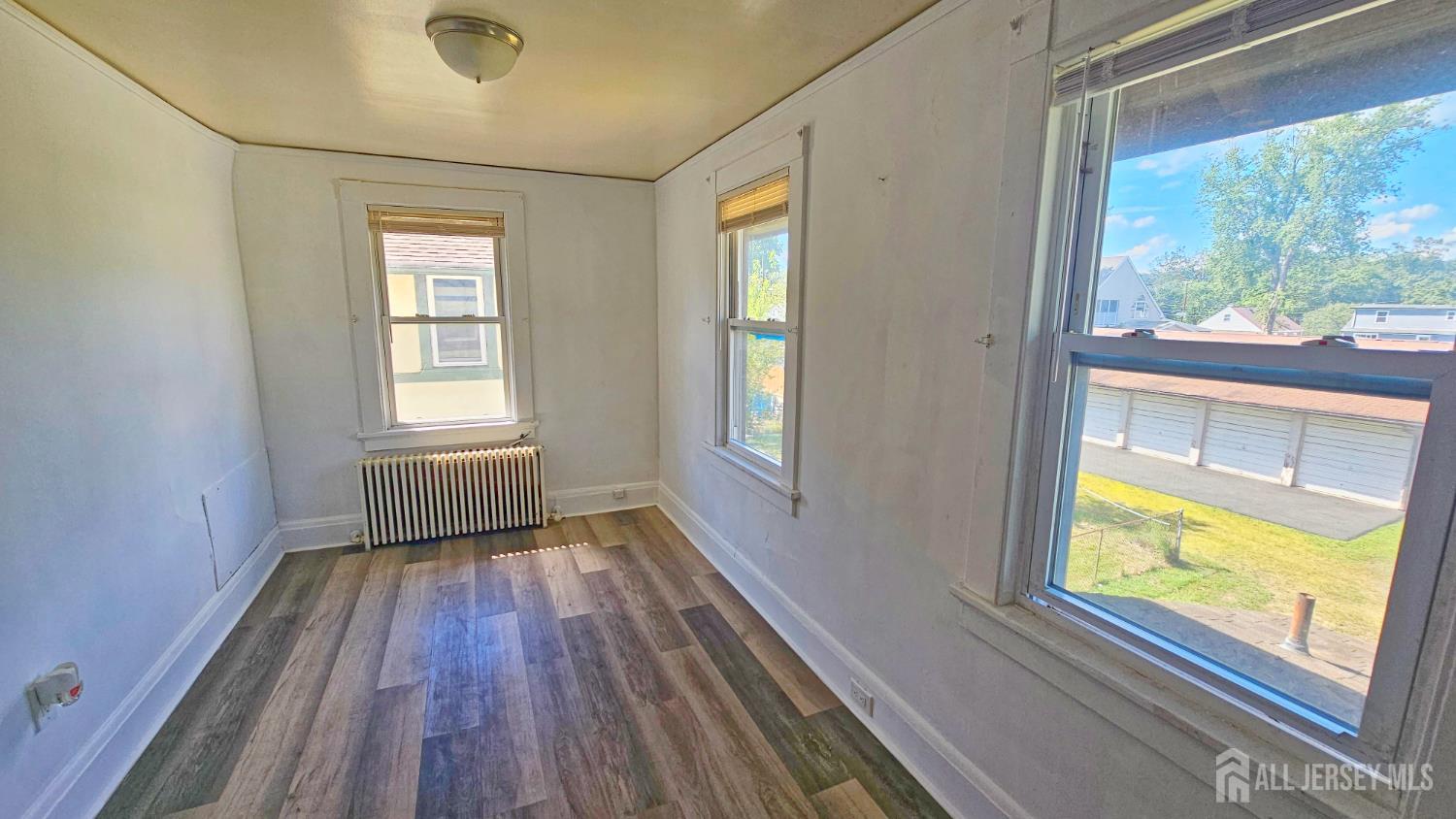 417 B Chestnut Street Middlesex, NJ 08846 - Photo 7 of 9 a view of an empty room with a window and wooden floor