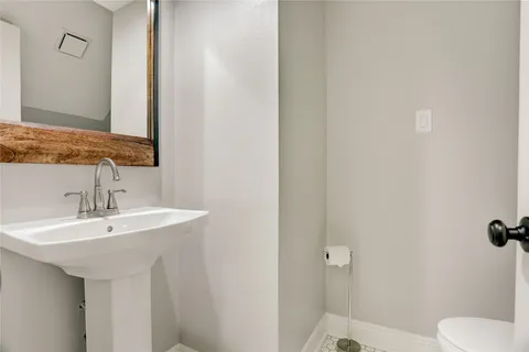 a spacious bathroom with a granite countertop sink a toilet a shower and a mirror