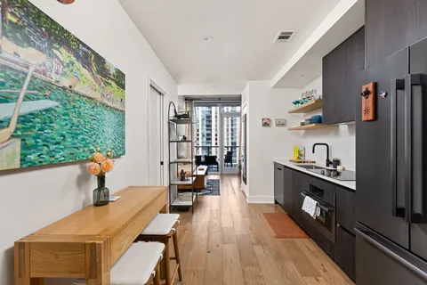 a kitchen with stainless steel appliances a stove a sink dishwasher and cabinets with wooden floor