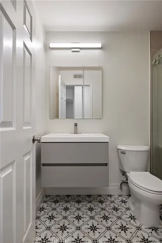 a bathroom with a sink mirror vanity and toilet