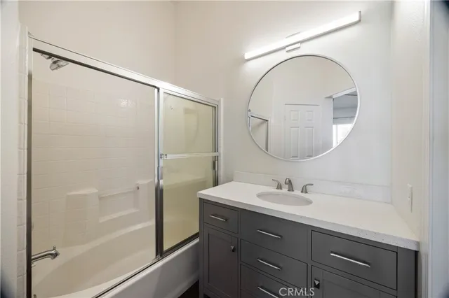 a bathroom with a sink mirror and a shower