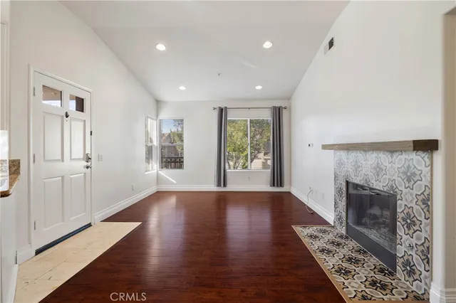 an empty room with windows and fireplace