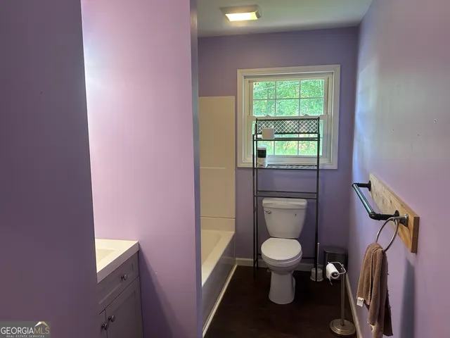 a reading room with wooden floor and a window