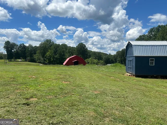 a view of a field with a trees in the background