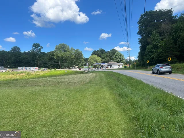 a view of swimming pool with outdoor seating and trees in the background